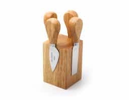 Kit queijo composto por faca reta, faca com ponta, espátula e garfo inox em uma base de madeira com ímãs.