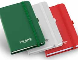 Caderno com capa dura em couro sintético, porta esferográfica e 160 folhas não pautadas.