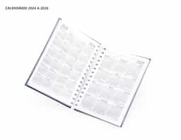 Agenda diária 2025 metalizada em Percalux com wire-o metálico. Possui "bolso" plástico atrás da capa, páginas de dados pessoais, calendário 2024 a 2026, mapa do Brasil, mapa-múndi, índice telefônico e planejamento.