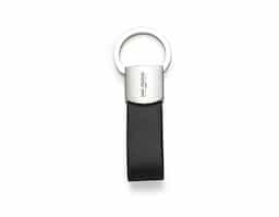 Chaveiro de metal com couro sintético e argola giratória, para utilizá-la basta levantá-la e rotacionar. Metal frente lisa e verso com um parafuso inferior.