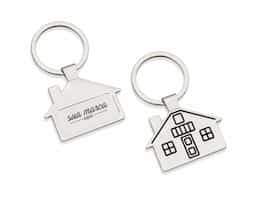 Chaveiro metal brilhante formato casa. Parte frontal com desenho em relevo das janelas e portas, verso com um retângulo no centro, ideal para personalização.