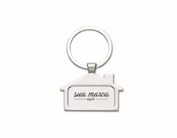 Chaveiro metal fosco formato casa. Parte frontal com desenho em relevo das janelas e portas, verso com um retângulo no centro ideal para personalização.