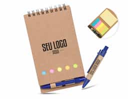 Bloco de anotações kraft com wire-o. Contém cinco blocos coloridos autoadesivos com aproximadamente 25 folhas, bloco amarelo autoadesivo com aproximadamente 25 folhas e bloco de folhas brancas pautadas com aproximadamente 70 folhas. Acompanha mini caneta de papelão com acabamentos plásticos e acionamento por clique.