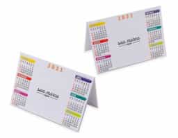 Calendário plástico de mesa com um semestre de cada lado. Impressa em papel offset e encapsulada em plástico rígido, possui a parte central branca ideal para personalização. 