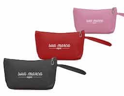 Necessaire impermeável de pvc, possui forro interno em poliéster e alça lateral externa para transporte.