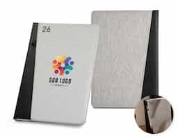 Agenda B5 em PET reciclado (100% rPET). Possui suporte para esferográfica (não inclusa) e marcador em fita. Está organizada num plano semanal. OBS: Esferográfica não inclusa