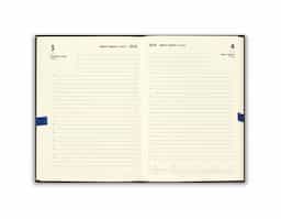 Agenda B5 em PU, com fecho magnético e peça metálica brilhante. Possui um suporte para esferográfica (inclusa) e marcador em fita. Está organizada num plano diário.