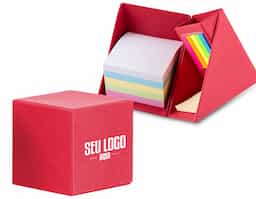 Bloco de anotações formato cubo com autoadesivos, abre e fecha em diagonal. Possui 5 blocos autoadesivos com aproximadamente 20 folhas cada, bloco amarelo com aproximadamente 50 folhas e conjunto de blocos com 4 cores e aproximadamente 100 folhas cada. Possui suporte para caneta, clips e afins no compartimento atrás bloquinhos coloridos.