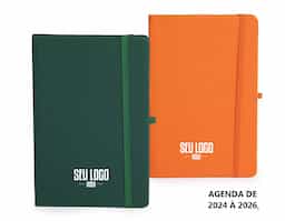 Planner com capa dura emborrachada, marca-páginas em fita de cetim, elástico para fechamento e suporte para caneta. Apresenta páginas dedicadas a dados pessoais, calendários de 2025 até 2027 e espaço para anotações diárias e semanais ao longo de todo ano de 2026.