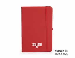 Planner com capa dura emborrachada, marca-páginas em fita de cetim, elástico para fechamento e suporte para caneta. Apresenta páginas dedicadas a dados pessoais, calendários de 2025 até 2027 e espaço para anotações diárias e semanais ao longo de todo ano de 2026.