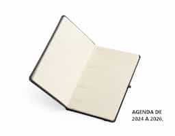 Planner com capa dura em cromato, marca-páginas em fita de cetim, elástico para fechamento e suporte para caneta. Apresenta páginas dedicadas a dados pessoais, calendários de 2025 a 2027 e espaço para anotações diárias e semanais ao longo de todo o ano de 2026.