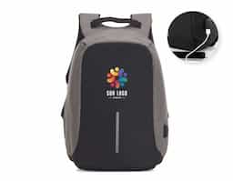 Mochila anti-furto de poliéster. Pensando na segurança do usuário foi confeccionado o compartimento principal na área traseira, impossibilitando a abertura do produto mesmo com a mochila na costa do usuário. Possui dispositivo com entrada USB na parte externa com cabo USB acoplado internamente; permitindo a conexão de um carregador portátil na área interna e a conexão de um eletrônico na área externa, viabilizando a carga e utilização do eletrônico enquanto caminha. Área interna do compartimento principal: bolso para notebook de 15,6 polegadas, bolso para tablet, quatro bolsos para acessórios, possui nas laterais internas sistema de velcro, maximizando a segurança da mochila. Parte frontal com faixa refletiva, alças para as costas ajustáveis revestidas com espuma para um maior conforto sendo uma delas com bolso de zíper, alça para mãos e alça horizontal para encaixe em malas de viagem.