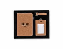 Kit viagem com 3 peças composto por porta-passaporte e tag identificadora de bagagem com alça, ambos com acabamento em cortiça. Acondicionado em estojo de papel com berço espumado e revestido em veludo, oferece praticidade e segurança na identificação de itens durante viagens.