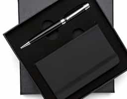 Kit executivo 2 peças. Acompanha: caneta metal preta com anel, detalhes em prata e escrita preta e caderneta tipo moleskine em couro sintético com aproximadamente 80 folhas amarelas pautadas.