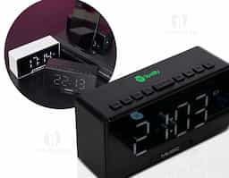 Caixa de som multimídia com relógio despertador e suporte para celular. Produzida em plástico e com borrachas antiderrapantes na área inferior, a caixa de som tem a área frontal com display de LED, além de um compartimento com suporte para celular – uma espécie de "gaveta" aonde é exibido (MUSIC), basta puxá-la ter acesso ao compartimento. A caixa de som executa nos modos bluetooth, rádio FM, cartão TF-microSD e entrada auxiliar P2. Acompanha cabo USB e manual em inglês.