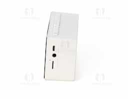 Caixa de som multimídia com relógio despertador e suporte para celular. Produzida em plástico e com borrachas antiderrapantes na área inferior, a caixa de som tem a área frontal com display de LED, além de um compartimento com suporte para celular – uma espécie de "gaveta" aonde é exibido (MUSIC), basta puxá-la ter acesso ao compartimento. A caixa de som executa nos modos bluetooth, rádio FM, cartão TF-microSD e entrada auxiliar P2. Acompanha cabo USB e manual em inglês.