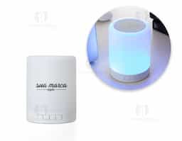 Caixa de som multimídia com luzes. Material plástico resistente na cor branca fosca, parte superior com falante e sensor touch para troca de luzes.