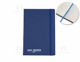 Caderneta tipo moleskine em couro sintético com marcador de página em cetim e fita elástica para fechar. Contém aproximadamente 80 folhas com pauta.