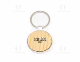 Chaveiro redondo de metal, destacando-se pela frente adornada com detalhe em bambu natural e verso liso. Combina funcionalidade e um toque de elegância natural, perfeito para quem aprecia acessórios simples e sofisticados ao mesmo tempo.