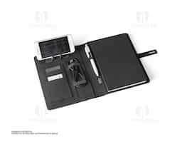 Pasta A5 em 300D poliéster reciclado (100% rPET) com carregador wireless embutido. A bateria tem capacidade para 5.000 mAh, potência de 10W, entrada/saída 5V/2.1A e cabo USB tipo C para carregar a bateria. A pasta contém no seu interior um bolso para smartphone até 6.5'', três espaços para cartões, quatro luzes LED, botão on/off, suportes para esferográfica (não inclusa), celular e cabo USB, um bloco de notas com capa em cartão preto e 64 folhas pautadas de cor marfim, em papel proveniente de gestão florestal sustentável. Na frente existe ainda uma impressão oval em preto para indicar a área de carga do wireless. Fornecido em caixa presente. 165 x 225 x 25 mm