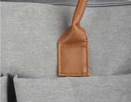 Mochila funcional em poliéster e couro sintético, equipada com compartimento principal com divisórias para organização. Possui alças de ombro e de mão, além de quatro bolsos laterais para armazenamento adicional. Ideal para uso diário e versátil.