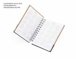 Agenda diária 2026 com capa dura em kraft, folhas brancas e encadernação Wire-O. Possui páginas dedicadas a dados pessoais, calendários de 2025 até 2027, orçamento pessoal, planejamento mensal, anotações diárias lista de contatos e aniversários do mês.