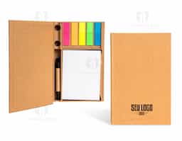 Tudo em seu lugar, prontinho para as anotações! Nosso Bloco de Anotações Ecológico é perfeito para manter a organização enquanto se registra ideias. Feito de material kraft, ele vem com 100 folhas brancas para anotações, 5 marcadores autoadesivos coloridos para destacar o que é importante, 7 clips guardados em uma gavetinha prática e uma mini caneta de papelão com carga esferográfica azul. E ainda conta com espaço para armazenar a caneta e dois suportes porta-caneta, garantindo praticidade no dia a dia. Este bloco é tudo o que o seu cliente precisa para dias repletos de anotações.