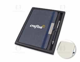 Kit composto por caderno de anotações e caneta metálica. O caderno, com capa dura, é feito de PET reciclado e contém 80 folhas pautadas, proporcionando uma opção sustentável e prática para o dia a dia. A caneta metálica completa o conjunto com elegância e funcionalidade.