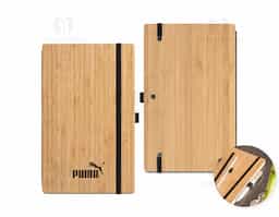 Caderno A5 de capa e contracapa em placa de bambu e lombada em poliéster 100% reciclado (100% rPET). O interior contém 96 folhas pautadas com papel reciclado, suporte para esferográfica (não inclusa) e elástico para fecho do caderno. A cor e o resultado da impressão nos materiais naturais pode variar entre produtos. 140 x 210 mm