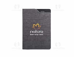 Caderno A5 com capa dura em tecido poliéster 100% reciclado (rPET). Contém 80 folhas pautadas em papel reciclado cor marfim, fita separadora e suporte para esferográfica no topo.