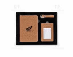 Kit viagem com 3 peças composto por porta-passaporte e tag identificadora de bagagem com alça, ambos com acabamento em cortiça. Acondicionado em estojo de papel com berço espumado e revestido em veludo, oferece praticidade e segurança na identificação de itens durante viagens.
