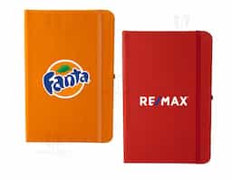 Caderneta em couro sintético com porta caneta, marcador de página em cetim e fita elástica para lacre. Contém aproximadamente 80 folhas pardas com pauta.