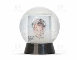 Globo de neve em plástico resistente, com glitter interno e porta-foto. A base preta é removível para inserção de uma foto no suporte interno, com dimensões de 8,5 cm x 4,7 cm, unindo decoração e funcionalidade em um só item.