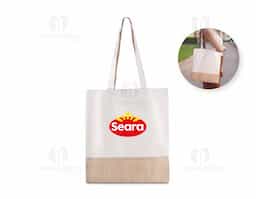 Sacola ecológica confeccionada em algodão cru 220g/m² com detalhe em juta, unindo resistência e charme rústico. Possui alças de 30 cm de altura, confortáveis e ideais para transporte no dia a dia. Perfeita para ações promocionais, feiras, eventos e uso pessoal, oferecendo praticidade, sustentabilidade e estilo.