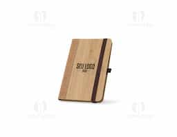Caderno de bolso de capa dura em folha de bambu e cortiça. Contém 160 páginas, em papel 100% reciclado, pautadas cor de marfim, fita separadora, suporte para esferográfica (não inclusa) e elástico para fecho do caderno.