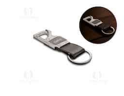 Chaveiro em metal com tira em couro sintético, que combina elegância e praticidade. Equipado com mosquetão para fácil fixação e função abridor de garrafas, é um acessório versátil para o dia a dia. Um brinde corporativo útil e sofisticado para destacar sua marca.