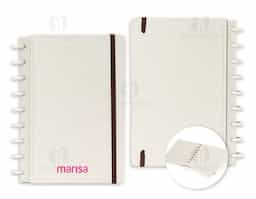 Caderno de capa dura em papel reciclado, com fechamento em elástico e encadernação em discos de fibra de arroz, que permitem adicionar ou retirar folhas compatíveis. Possui páginas dedicadas para dados pessoais, calendários de 2025 e 2026 e um manual para troca e retirada de folhas. Possui cerca de 80 folhas em papel reciclado pautadas.